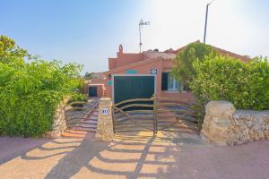 a house with a sign in front of it at Villa Mares in Cala en Porter