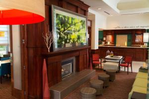a living room with a fireplace and a kitchen at Hilton Garden Inn Tampa East Brandon in Tampa
