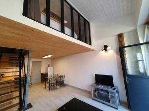 a living room with a staircase and a television at APPARTEMENT CENTRE VILLE AU CALME JARDIN et PARKING PUBLIC in La Rochelle
