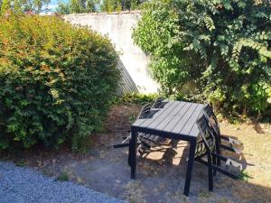 una mesa de picnic negra sentada en un patio en APPARTEMENT CENTRE VILLE AU CALME JARDIN et PARKING PUBLIC, en La Rochelle