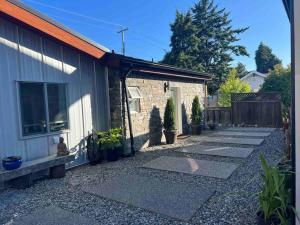 a backyard of a house with a stone driveway at Private Bright Modern Studio! Queen bed ! in Victoria