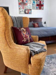 a brown chair with a pillow in a living room at Private Bright Modern Studio! Queen bed ! in Victoria