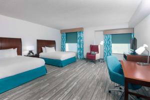 a hotel room with two beds and a desk at Hilton Garden Inn Tampa Riverview Brandon in Brandon +26 photos