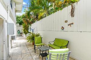 a patio with two green chairs and a table at Soleado Hotel in Fort Lauderdale