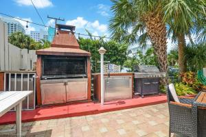 an outdoor kitchen with a grill on a patio at Soleado Hotel in Fort Lauderdale