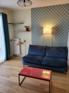 um sofá azul numa sala de estar com uma mesa em Bel appartement à Rueil-Malmaison em Rueil-Malmaison