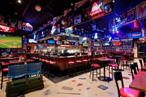 a bar with tables and chairs and neon signs at Hilton Garden Inn Mount Holly/Westampton in Westampton Township