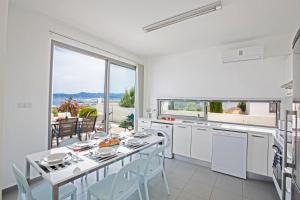 cocina con mesa y sillas y ventana grande en Jenny Villa 23, en Polis Chrysochous