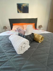ein Bett mit zwei Handtüchern und Kissen darauf in der Unterkunft Cozy apartment with two bedrooms with a sea view in Peraia