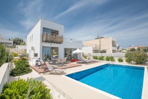 a villa with a swimming pool and a house at Jenny Villa 23 in Polis Chrysochous