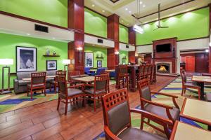 a restaurant with tables and chairs and a fireplace at Hampton Inn & Suites Owasso in Owasso