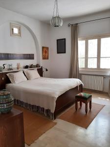 a bedroom with a large bed and a large window at Dar Mayya in La Marsa