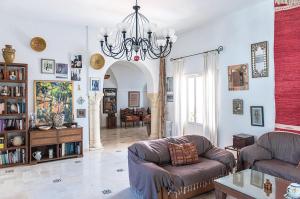 a living room with two chairs and a chandelier at Dar Mayya in Tunis