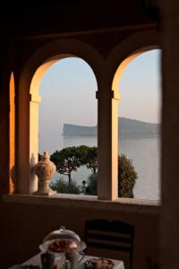 a table with a view of the water from a window at La Criolda Charming Villa in San Felice del Benaco