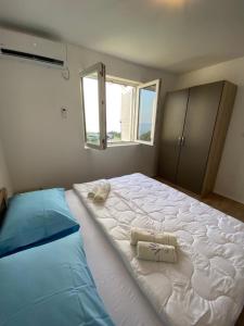 ein großes weißes Bett in einem Zimmer mit Fenster in der Unterkunft Apartment Leonardo in Makarska