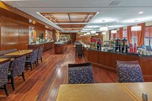 um restaurante com mesas e cadeiras e um bar em DoubleTree by Hilton Tulsa at Warren Place em Tulsa