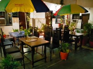 un restaurante con mesas, sillas y sombrillas en Hotel Sidhartha Walking Distance From TajMahal, en Agra