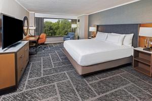 um quarto de hotel com uma cama e uma televisão de ecrã plano em DoubleTree by Hilton Tulsa at Warren Place em Tulsa