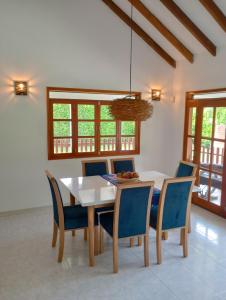 a dining room with a white table and blue chairs at Habitación tranquila en casa campestre in Pereira