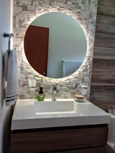 ein Badezimmer mit einem weißen Waschbecken und einem Spiegel in der Unterkunft Habitación tranquila en casa campestre in Pereira