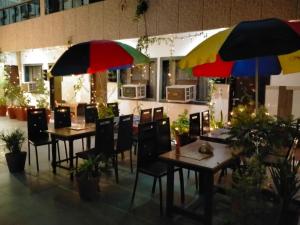 Hotel Sidhartha Walking Distance From TajMahal في آغْرا: طاولتين وكراسي مع مظلات في المطعم