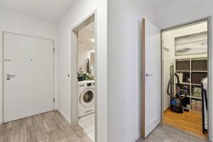 eine weiße Waschküche mit Waschmaschine und Trockner in der Unterkunft Modernes Apartment mit Heimkino und Netflix in Dresden in Dresden