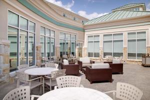 a patio with tables and chairs and windows at Hilton Garden Inn Tyler in Tyler