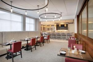 a restaurant with tables and chairs and a bar at Hilton Garden Inn Tyler in Tyler