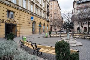a park with benches and a fountain in front of a building at Stylish NEW home with view on New York Palace in Budapest