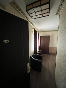une chambre avec une porte noire et une chaise dans l'établissement Flamingo Hostel, à Piteşti