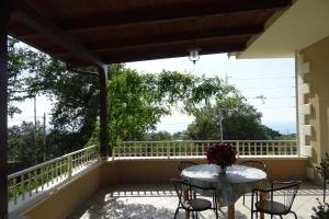 eine Terrasse mit einem Tisch und Stühlen auf dem Balkon in der Unterkunft B&B Nucria - Nocera Terinese in Nocera Terinese