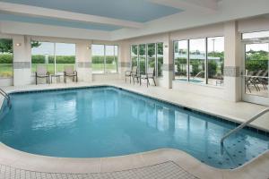 Hilton Garden Inn Knoxville West/Cedar Bluff في نوكسفيل: مسبح في الفندق مع الكراسي والطاولات