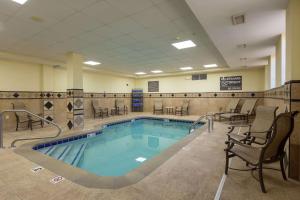 a swimming pool in a gym with chairs and tables at Hampton Inn & Suites Knoxville-Downtown in Knoxville