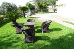 4 Korbstühle und ein Tisch im Gras in der Unterkunft B&B Nucria - Nocera Terinese in Nocera Terinese