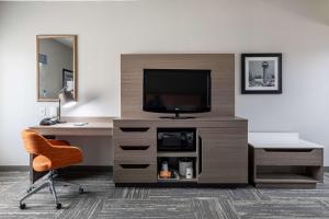 Habitación con escritorio, TV y silla. en Hampton Inn & Suites Knoxville-Downtown en Knoxville