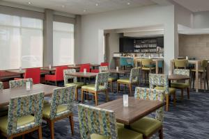 um restaurante com mesas e cadeiras e um bar em Hilton Garden Inn Knoxville West/Cedar Bluff em Knoxville