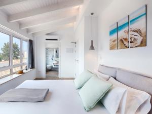Hostal Perla Blanca Altea في ألتيا: غرفة نوم بيضاء مع سرير أبيض كبير ونوافذ