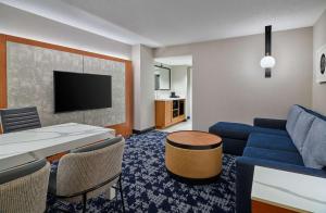 a living room with a blue couch and a tv at Embassy Suites by Hilton Washington DC Convention Center in Washington, D.C.