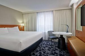 华盛顿Embassy Suites by Hilton Washington DC Convention Center的一间配有大床和桌子的酒店房间