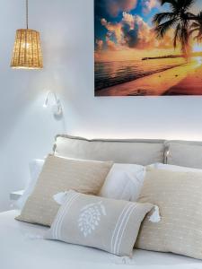 uma cama com duas almofadas e um quadro na parede em Hostal Perla Blanca Altea em Altea