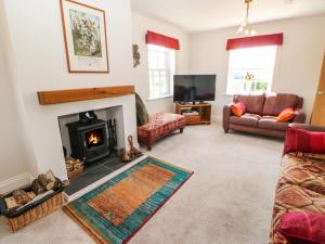a living room with a fireplace and a couch at Larch House in Penrith