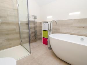 a bathroom with a bath tub and a shower at Larch House in Penrith +44 photos