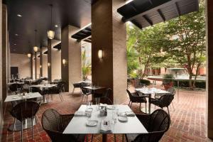 a restaurant with tables and chairs and a patio at Embassy Suites by Hilton Alexandria Old Town in Alexandria