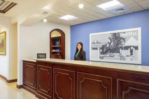 a woman standing behind a counter in a waiting room at Hampton Inn & Suites Wellington in Wellington