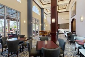 a restaurant with tables and chairs and windows at Hampton Inn & Suites Wellington in Wellington