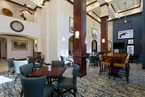 un restaurante con mesas y sillas y un reloj en la pared en Hampton Inn & Suites Wellington, en Wellington