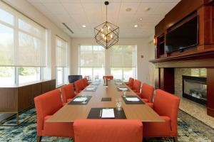 ein großer Konferenzraum mit einem langen Tisch und orangefarbenen Stühlen in der Unterkunft Hilton Garden Inn Winchester in Winchester