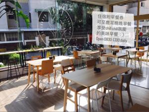 a restaurant with tables and chairs and a large window at 鹿耳宅宅 Lure Guesthouse in Tainan