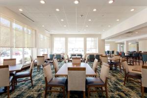 a dining room with tables and chairs and windows at Hilton Garden Inn Winchester in Winchester