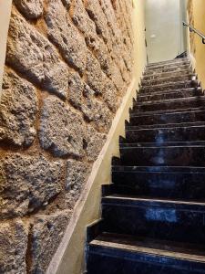 una pared de piedra y escaleras en un edificio en Palermo Inn Studios, en Palermo